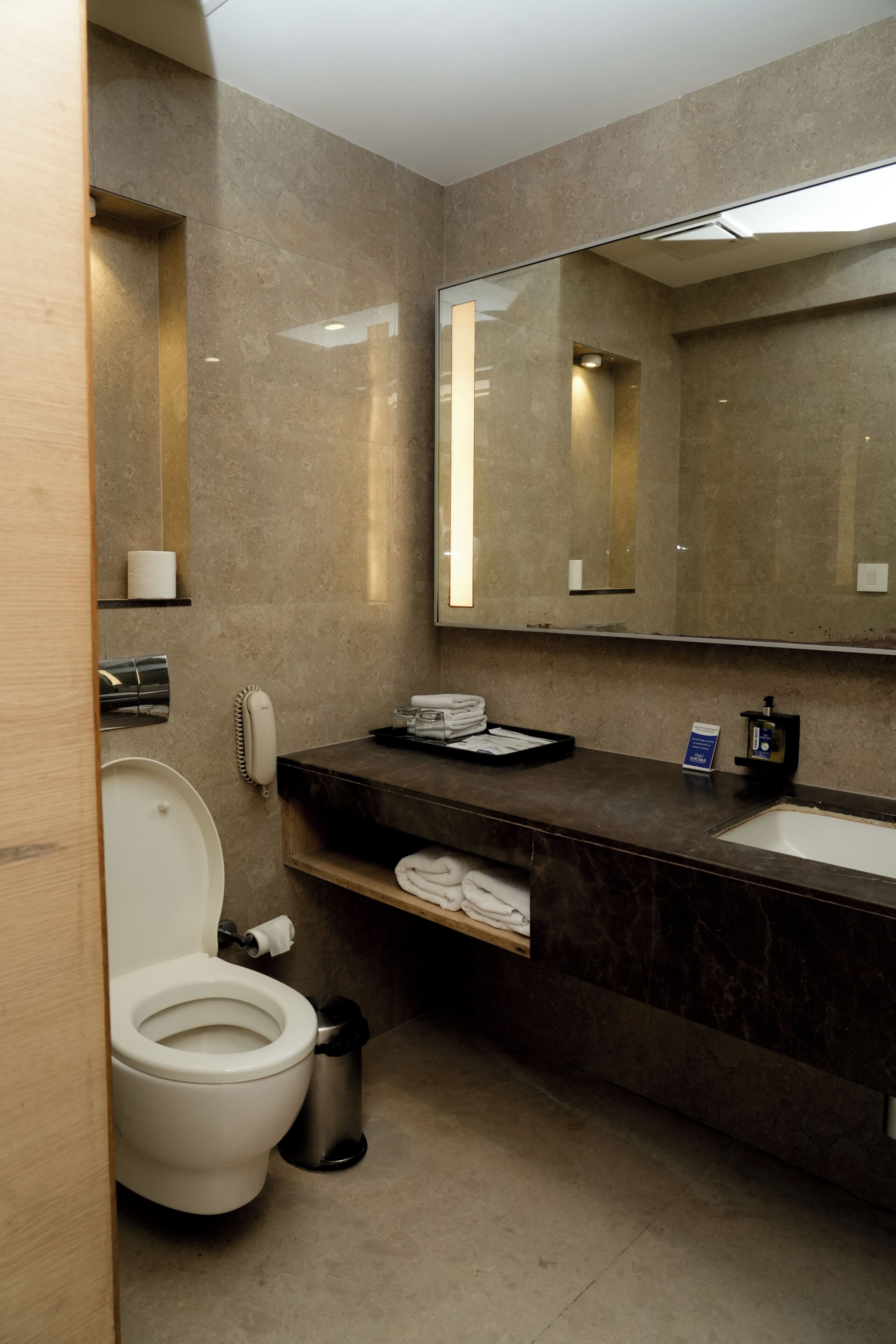 A modern bathroom with a toilet, sink, and mirror.