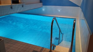 An indoor swimming pool with tiled walls and a blue floor. - AKZENT Hotel Koerner Hof (Dortmund)