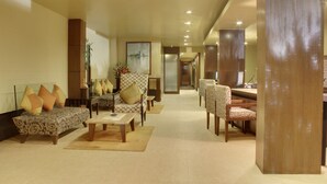 A spacious lobby with a sofa, armchairs, and a reception desk. - juSTa Hyderabad (Hyderabad)