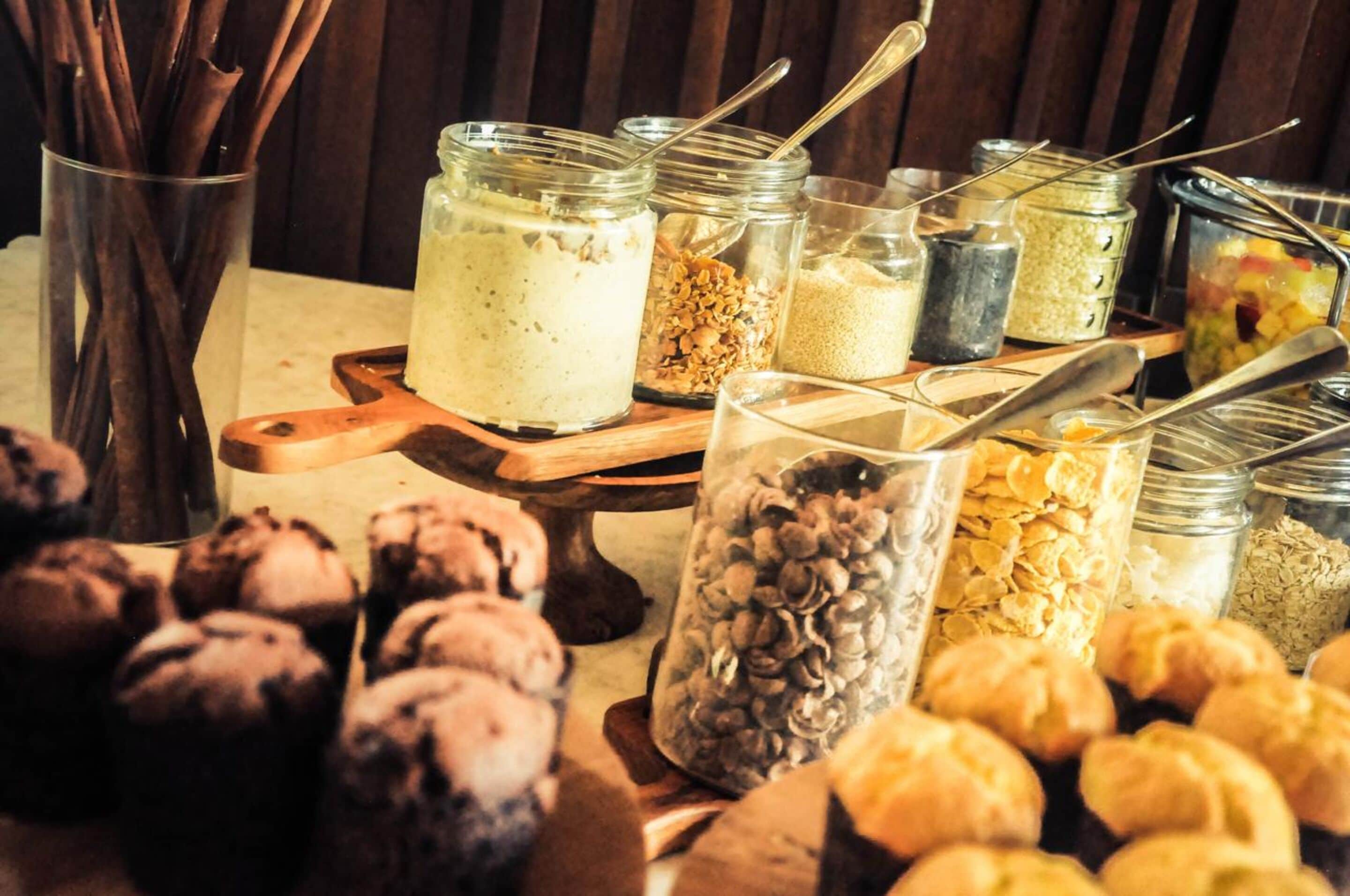 Un buffet con diversi cibi, tra cui barattoli di salse, cereali e dolci.
