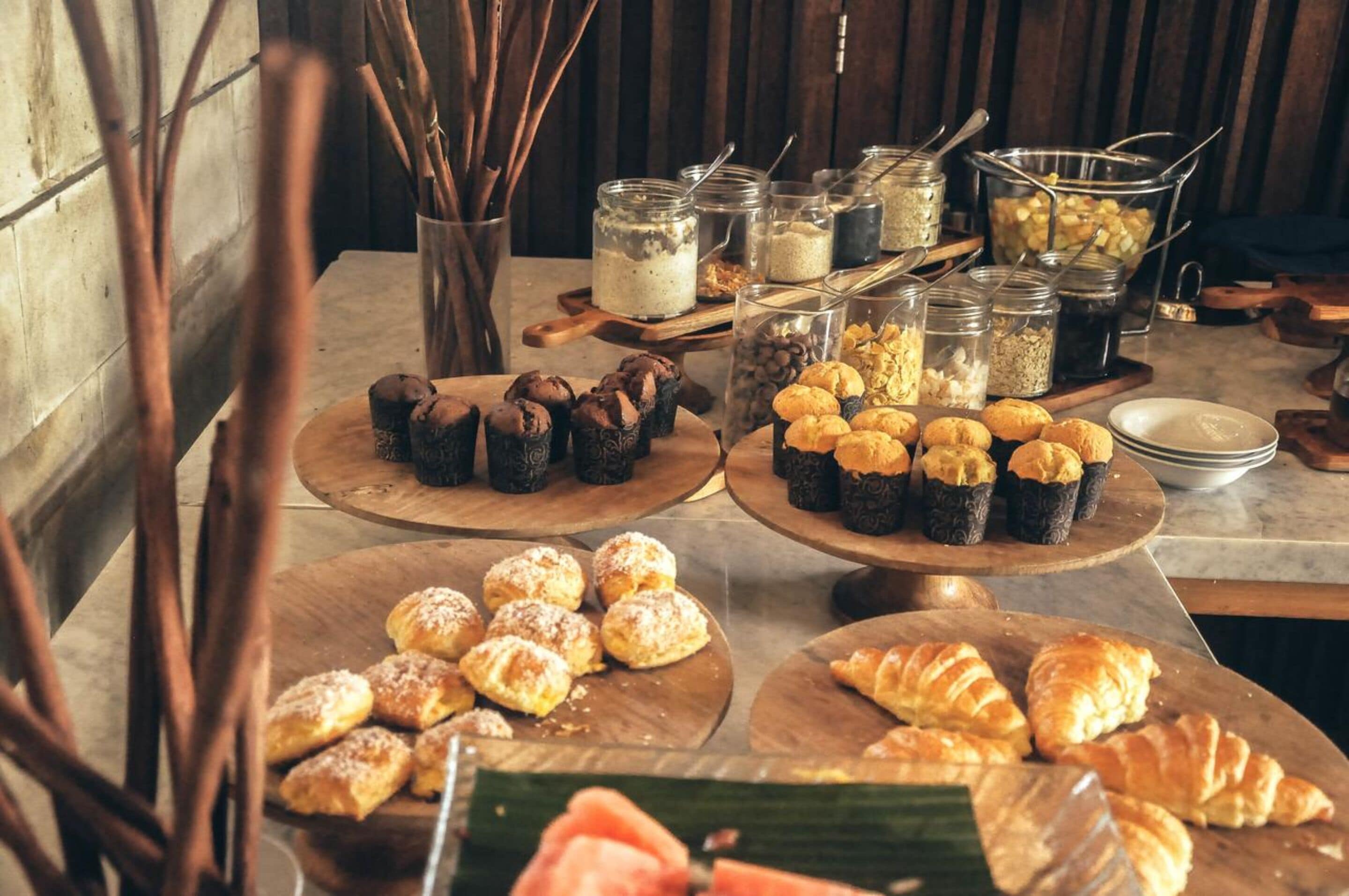 A buffet table with various pastries and food items.