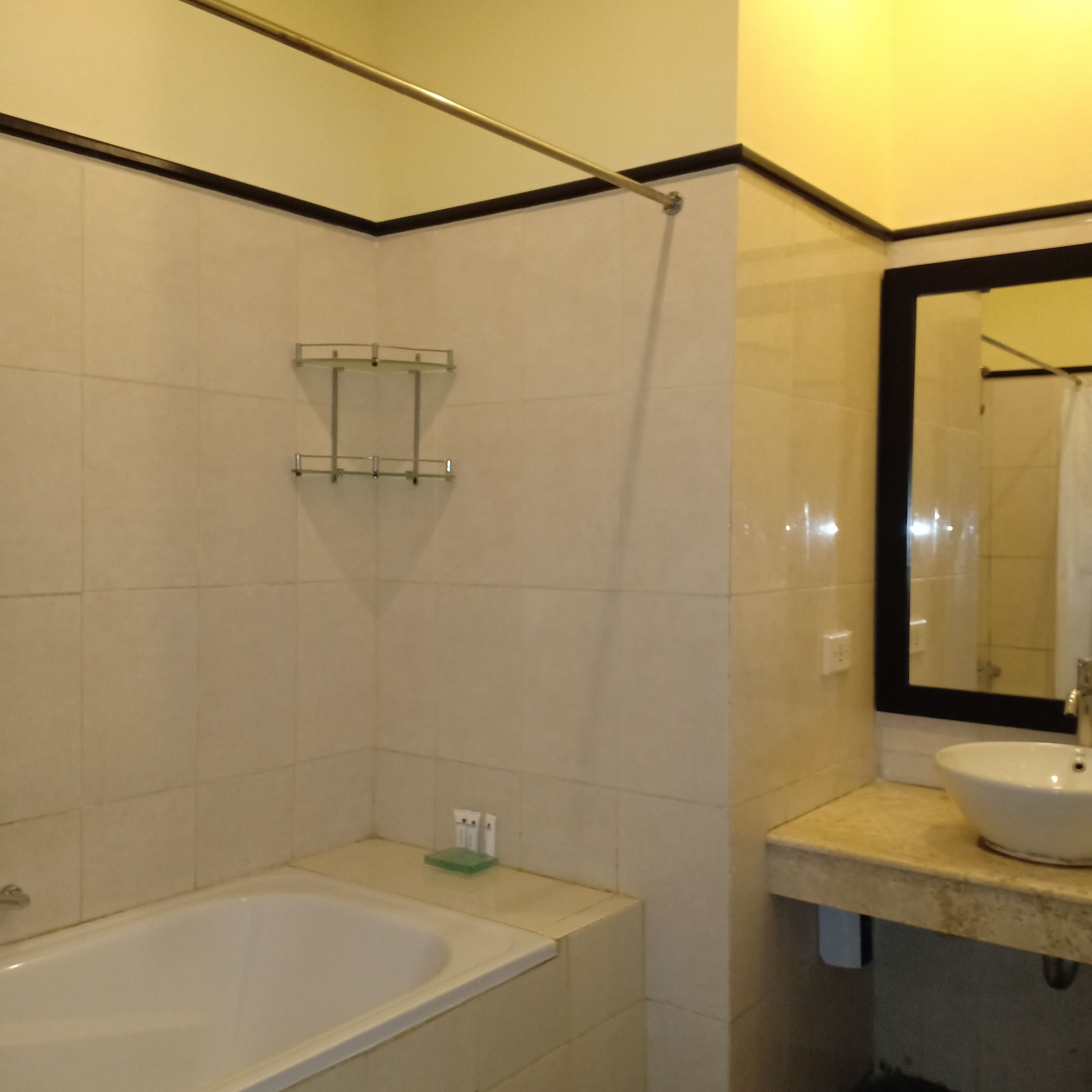 Un baño con bañera, lavabo, espejo y toallero.