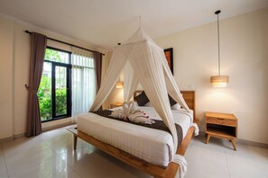 Ein Schlafzimmer mit Baldachinbett, einem Nachttisch aus Holz und Blick auf die grüne Umgebung.