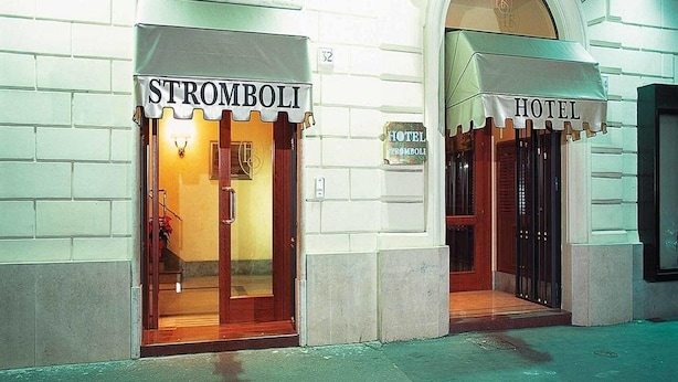 Un hôtel avec une enseigne indiquant « HÔTEL STROMBOLI » et une autre enseigne distincte indiquant simplement « STROMBOLI ».