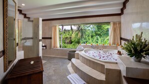 A bathroom with a large window, a bathtub, a shower, and a vanity with a mirror. - Kori Ubud Resort (Ubud)