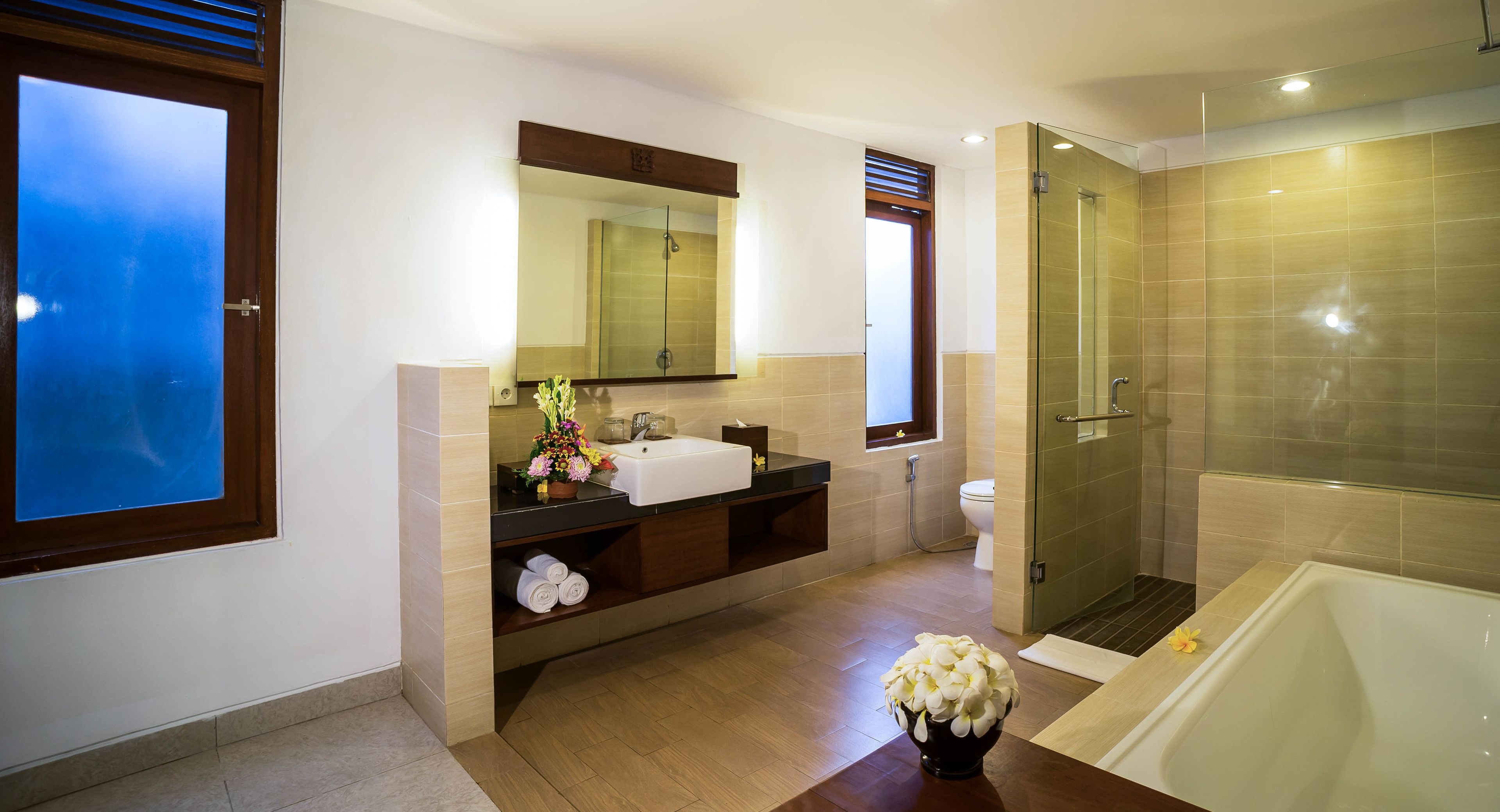 A modern bathroom with a glass-enclosed shower, a large sink, and a bathtub.