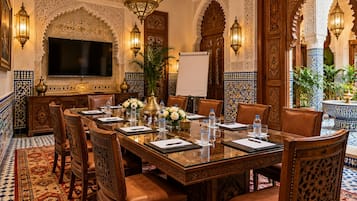A meeting room with a long table, chairs, a TV, and decorative elements.