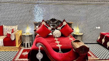 A room with a large bed, ornate wall decor, and patterned rugs.