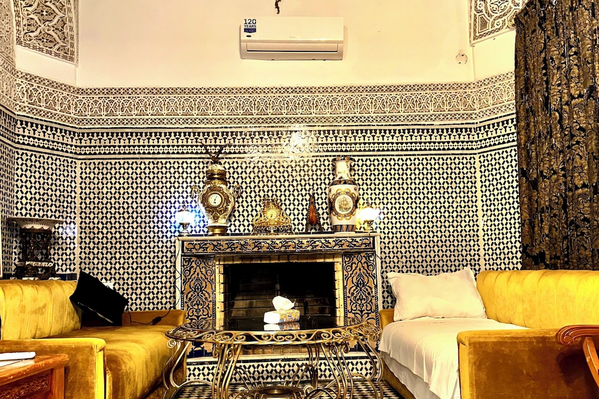 A room with a patterned floor, a fireplace, and two sofas.