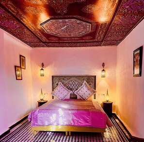 A room with a bed, two nightstands, and a patterned ceiling. - Riad Damia Suite &Spa (Fes)