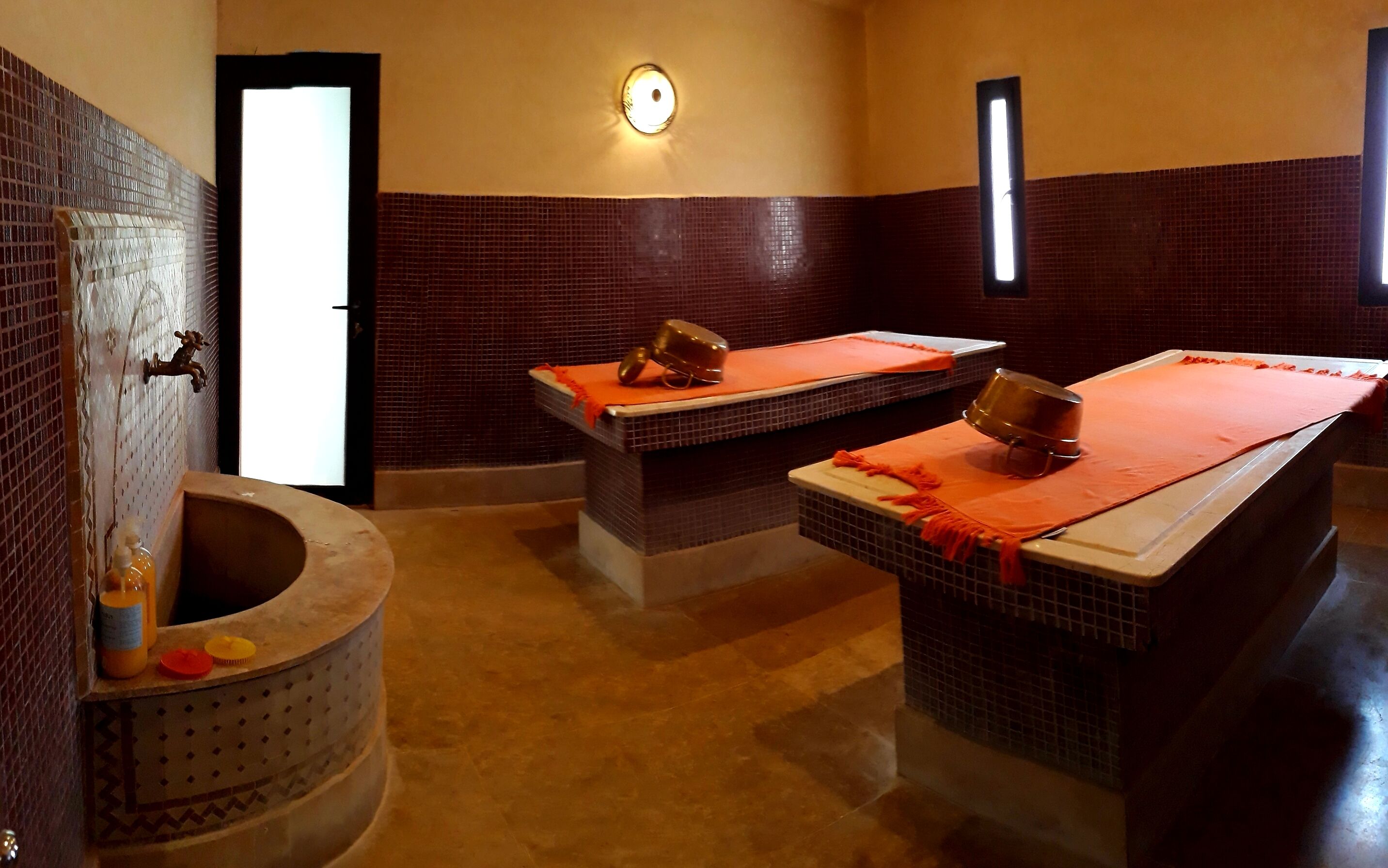 A bathroom with two sinks, a toilet, and a wall-mounted light fixture.