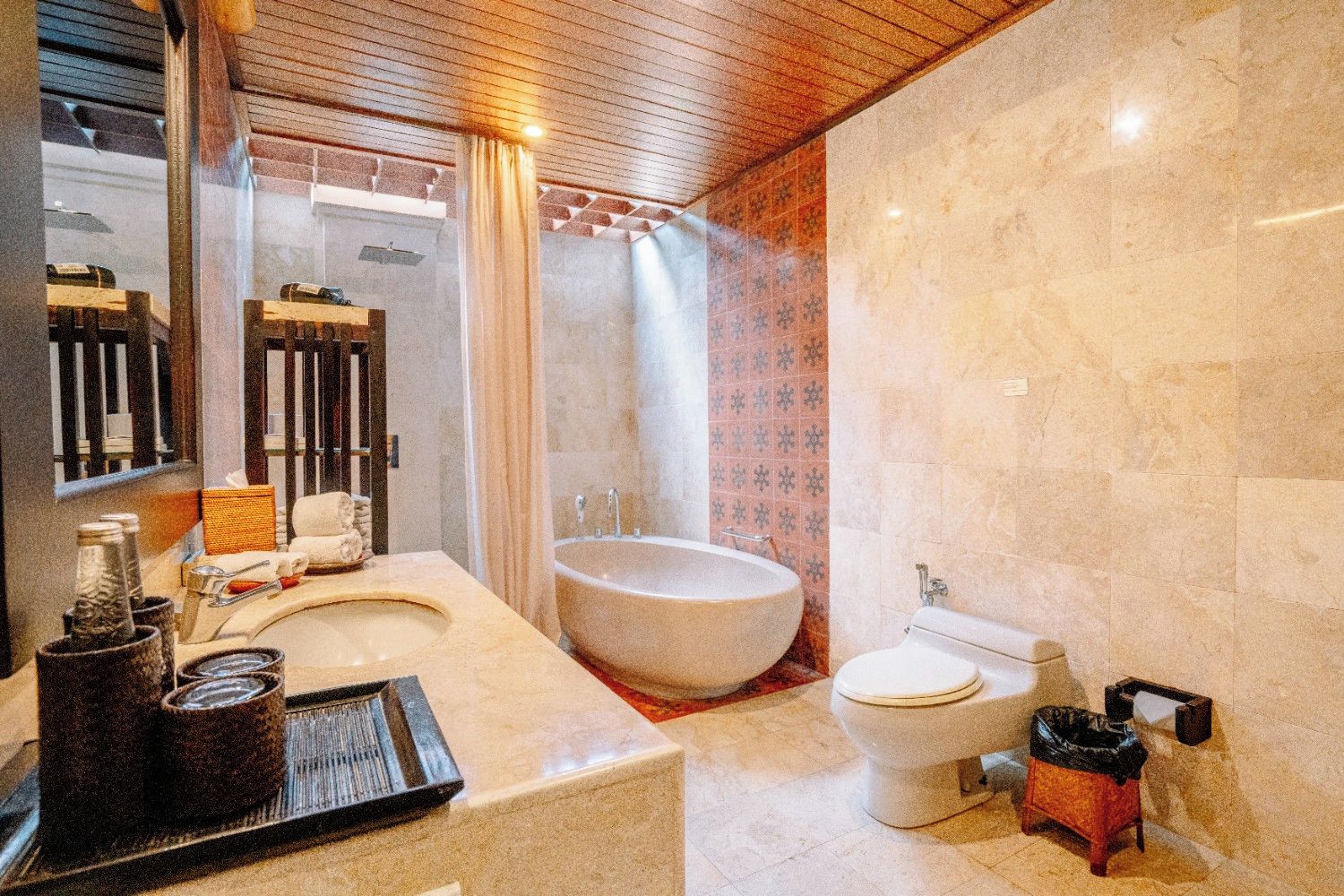 A bathroom with a large bathtub, a toilet, and a sink.