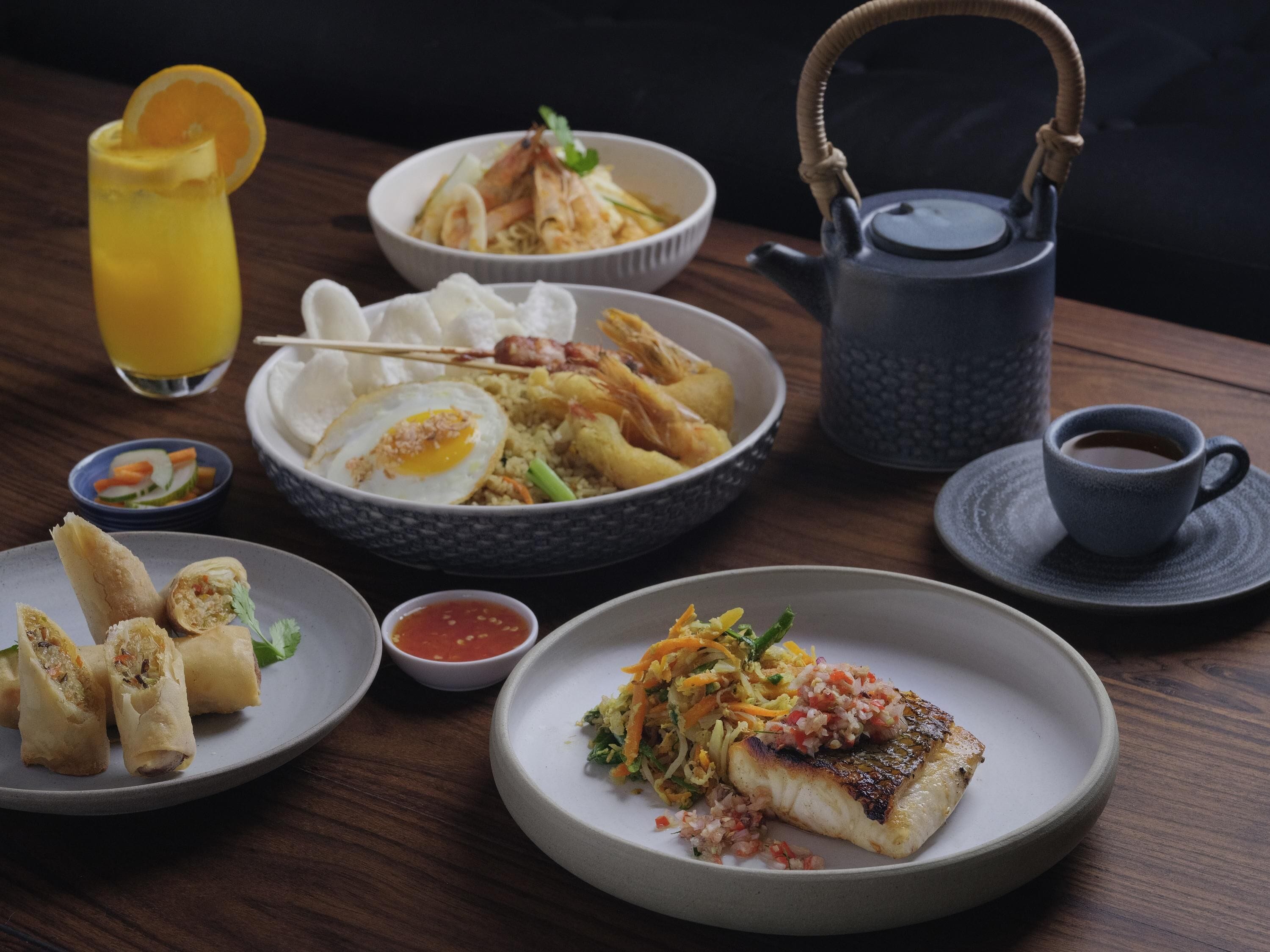 A table with various dishes, a teapot, and a cup of coffee.