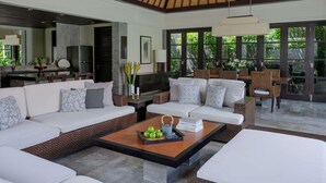 A spacious living area with a high ceiling, a dining area with wicker furniture, and a kitchen with modern appliances. - Peppers Seminyak (Seminyak)
