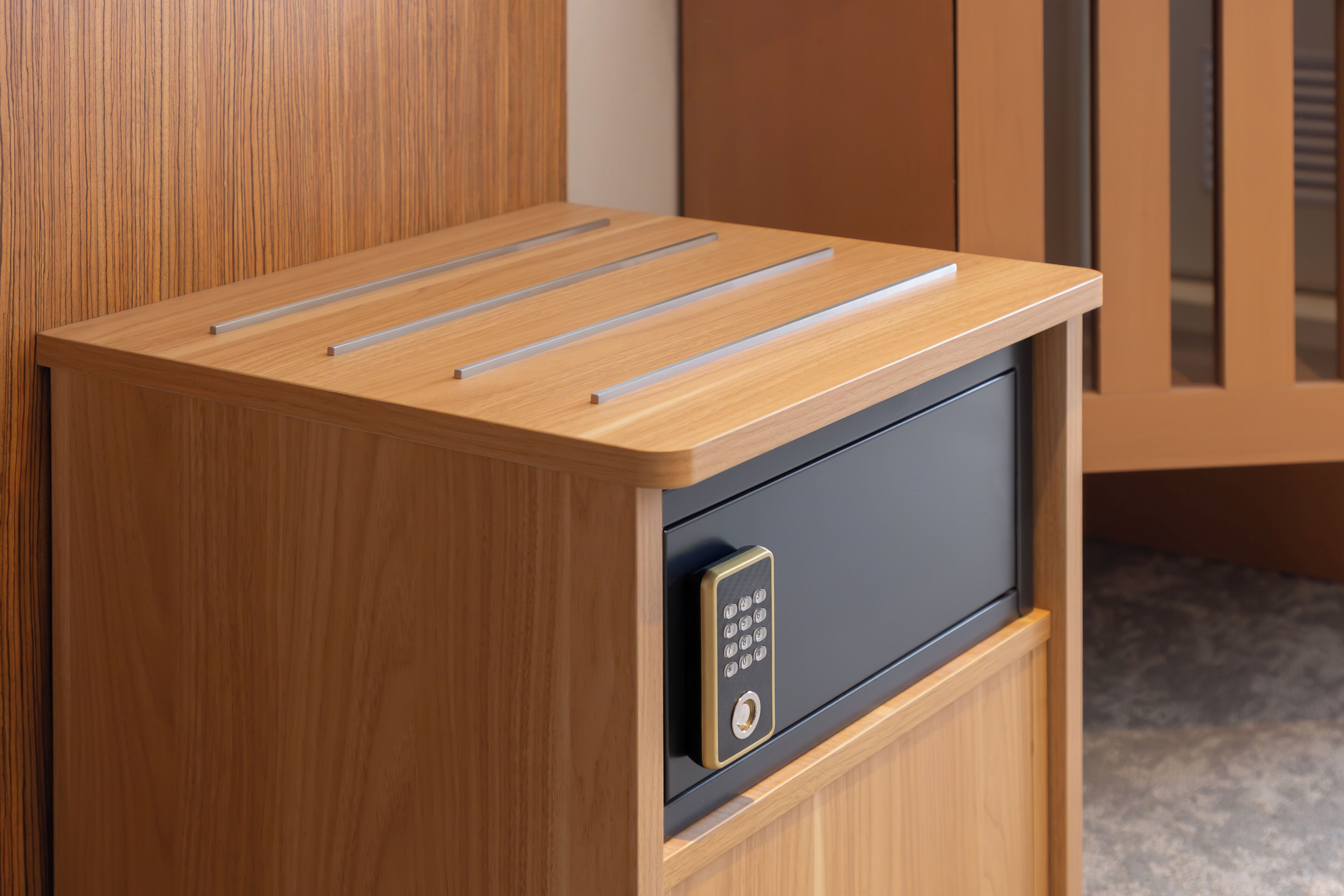 A wooden cabinet with a black drawer containing a keycard slot.