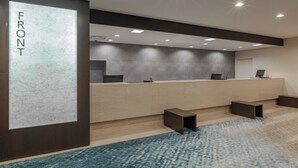 A reception area with a marble wall labeled "FRONT," a reception desk, and a blue patterned carpet. - Art Hotel Niigata Station (Niigata)