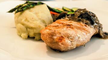A plate with a piece of grilled chicken and mashed potatoes.