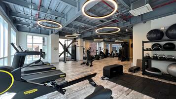 A gym with cardio machines, weightlifting equipment, and exercise balls.