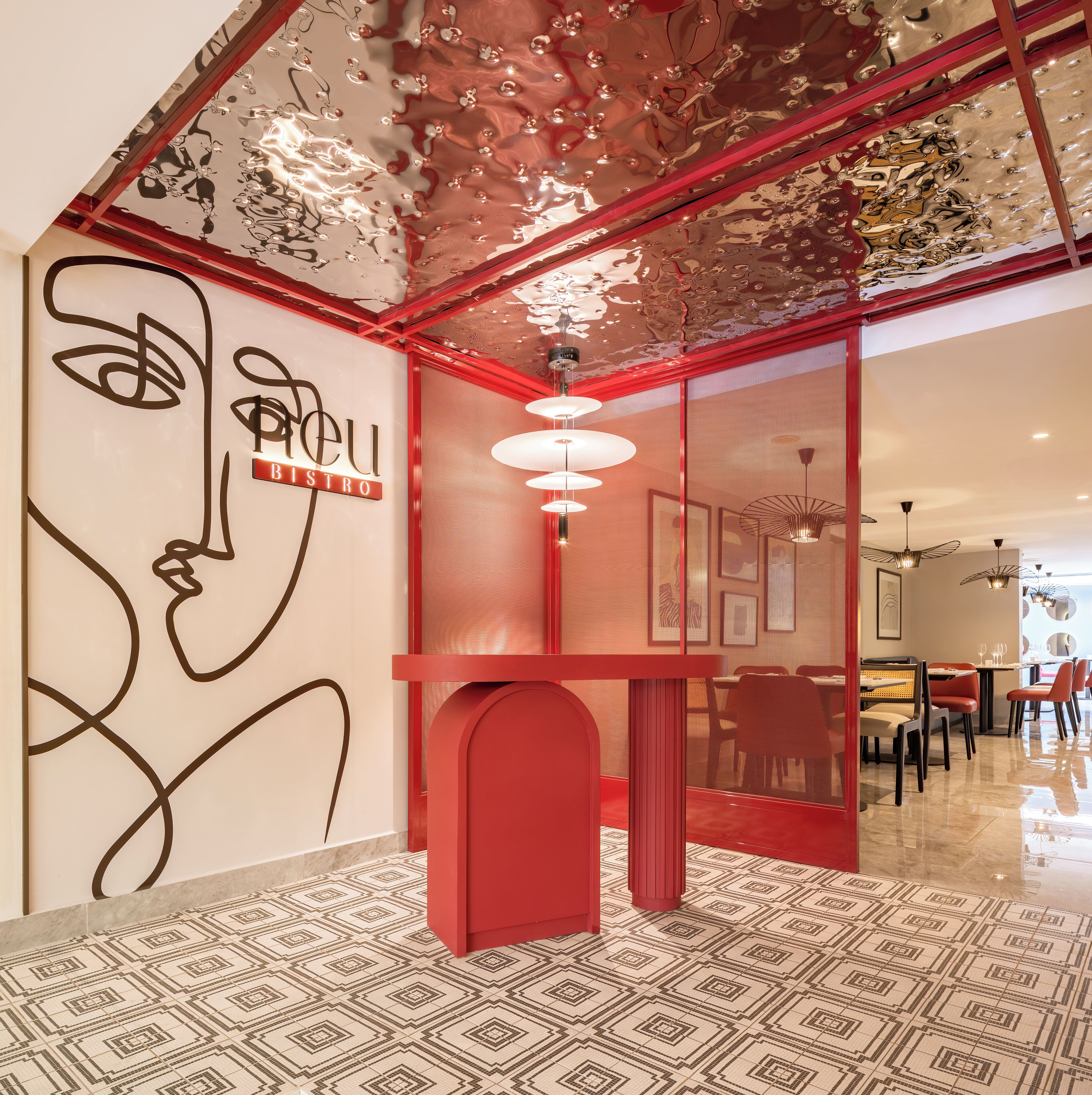 A modern interior with a geometric patterned floor, a red accent wall, and a ceiling with a unique design.