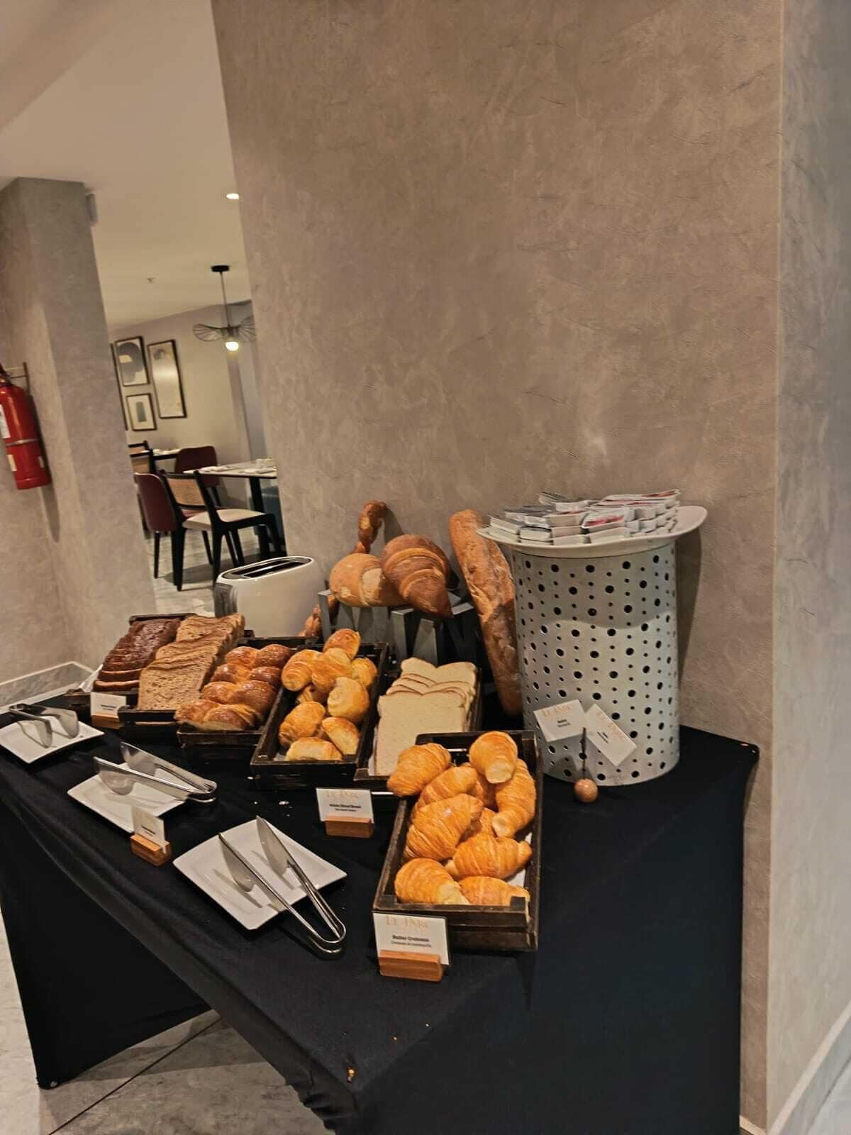 A buffet table with various baked goods, including bread, pastries, and croissants.