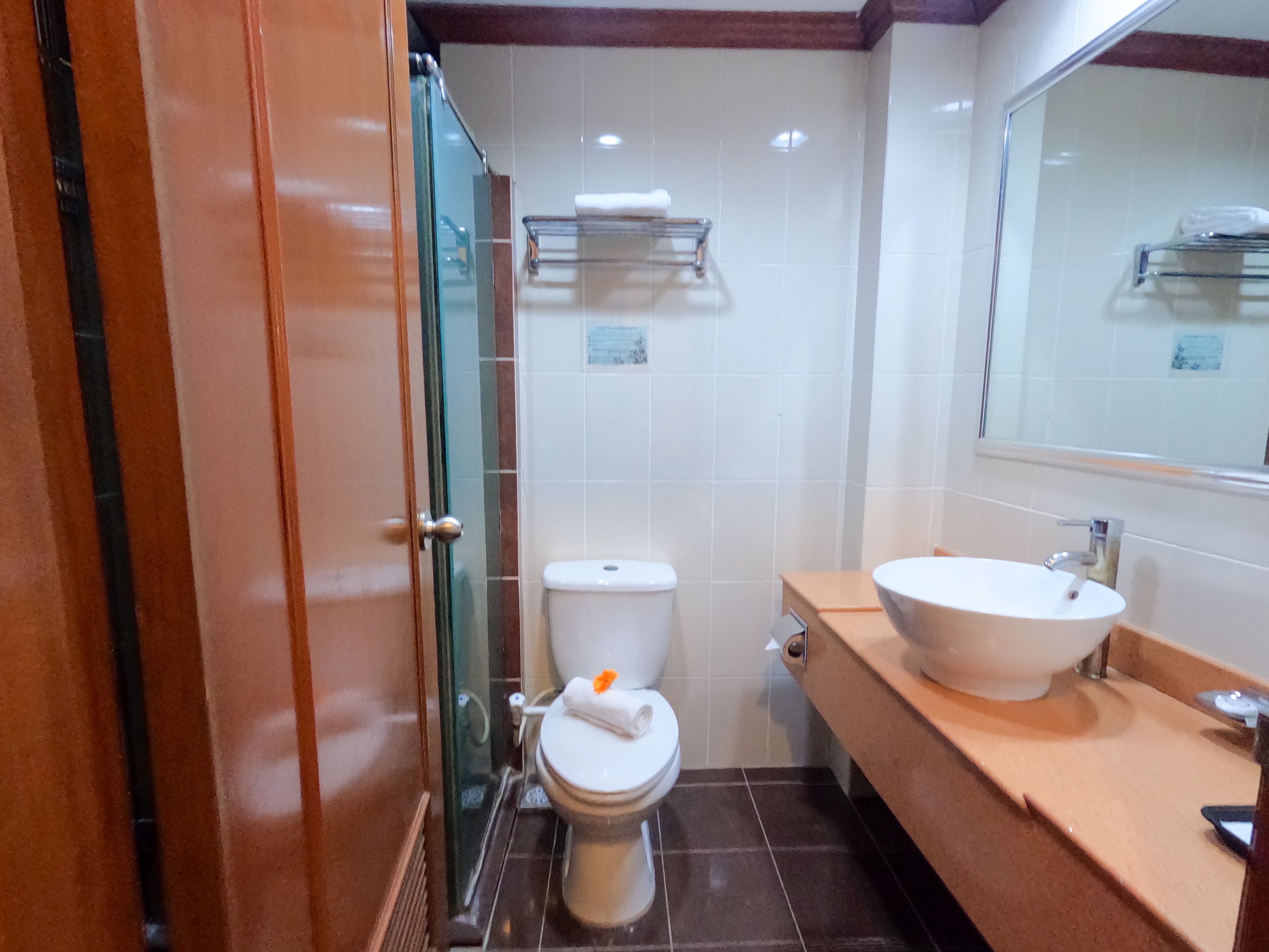 A bathroom with a toilet, a sink, and a glass shower enclosure.