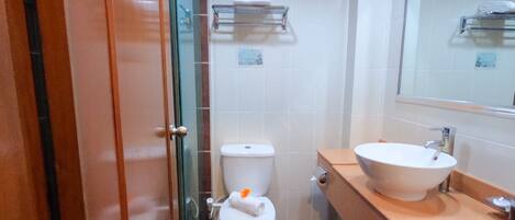 A bathroom with a toilet, a sink, and a glass shower enclosure.