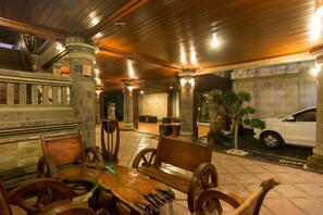 Un restaurante con mobiliario de madera, pilares de piedra y una pared de piedra.