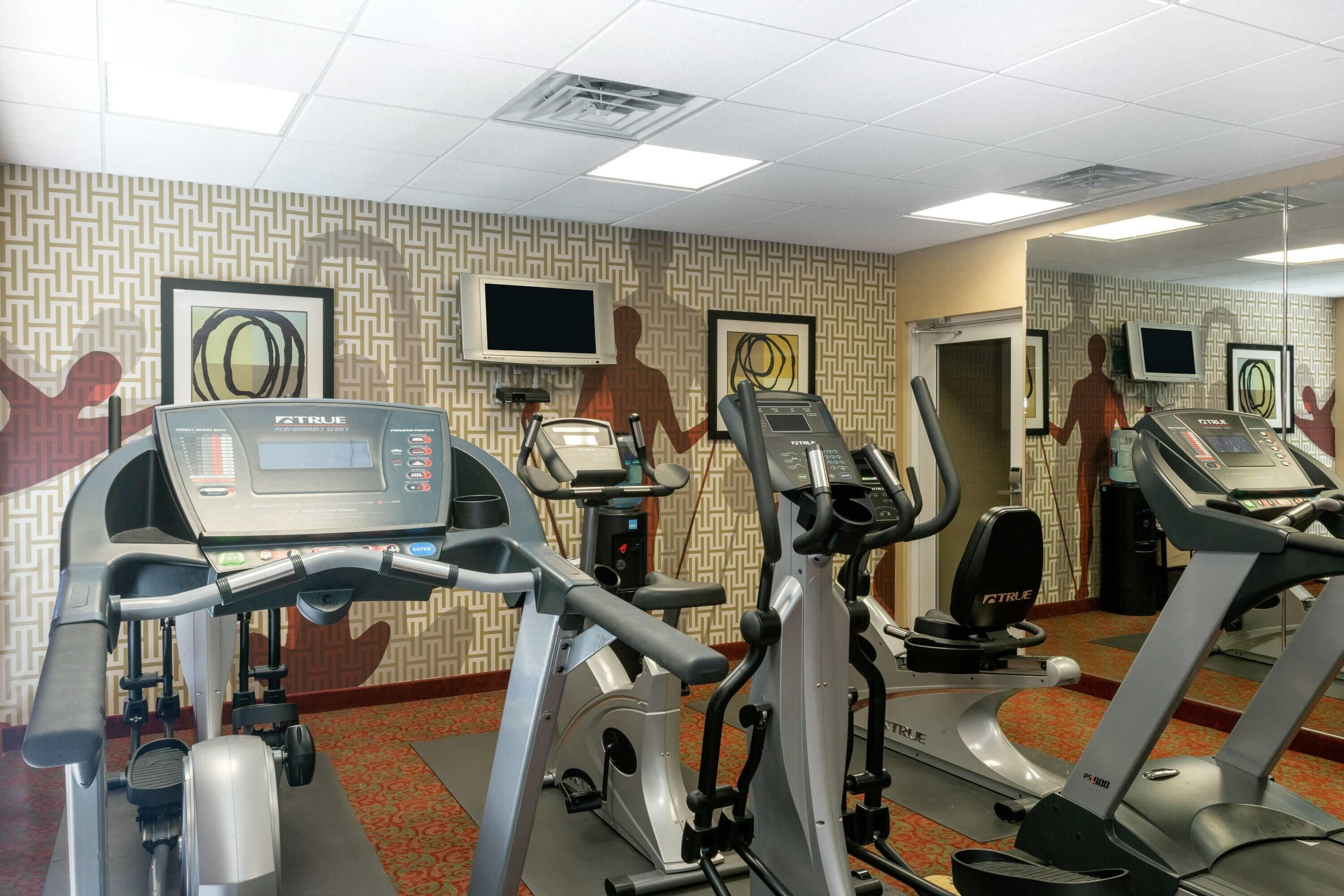A fitness center with treadmills, stationary bikes, and elliptical machines.