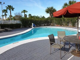 Una piscina al aire libre, sillones reclinables de piscina