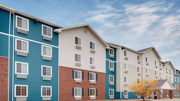 A row of multi-story residential buildings with a parking lot in front.