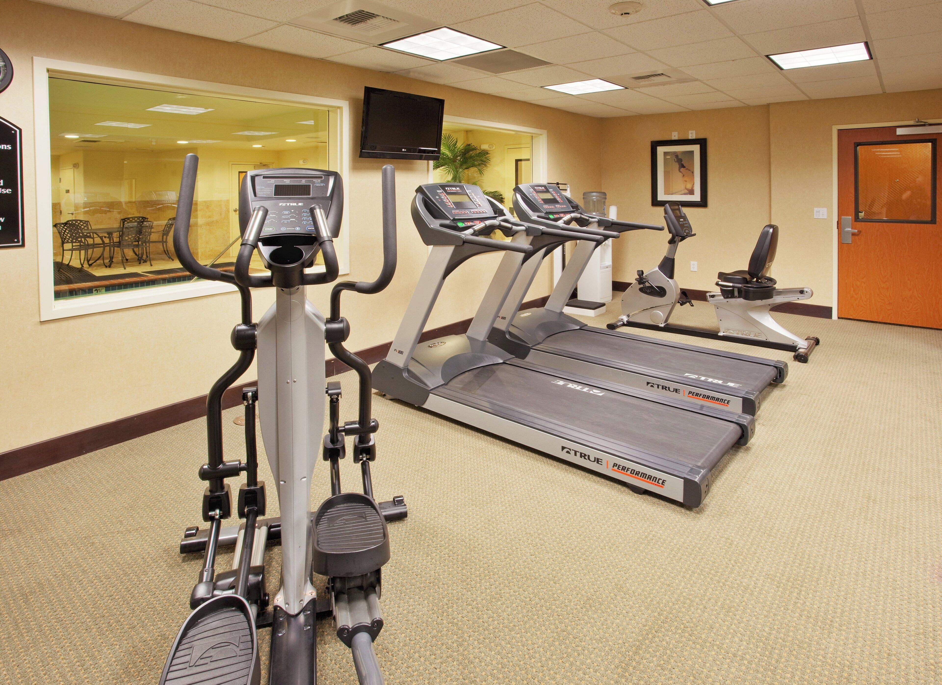 Et fitnesscenter med løbebånd og crosstrainere.