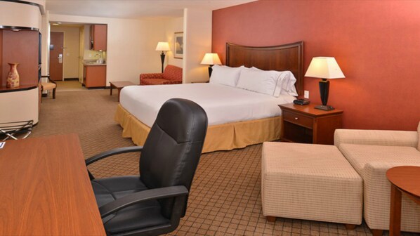 A hotel room with a bed, a desk, a chair, a sofa, and a lamp. - Holiday Inn Express Hotel & Suites Lincoln by IHG (Lincoln)