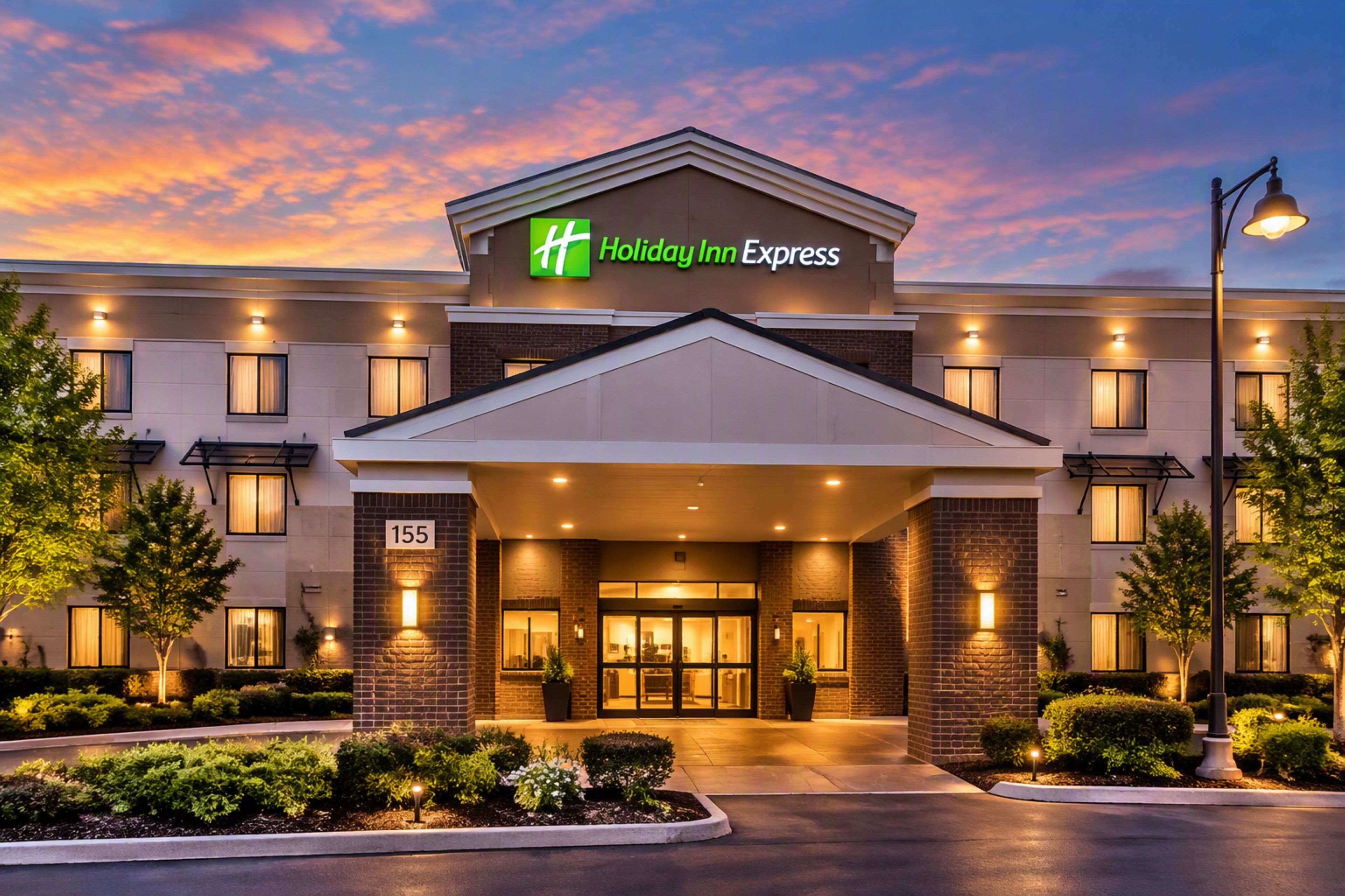 A Holiday Inn Express hotel with a modern facade, a prominent entrance, and a well-lit exterior.