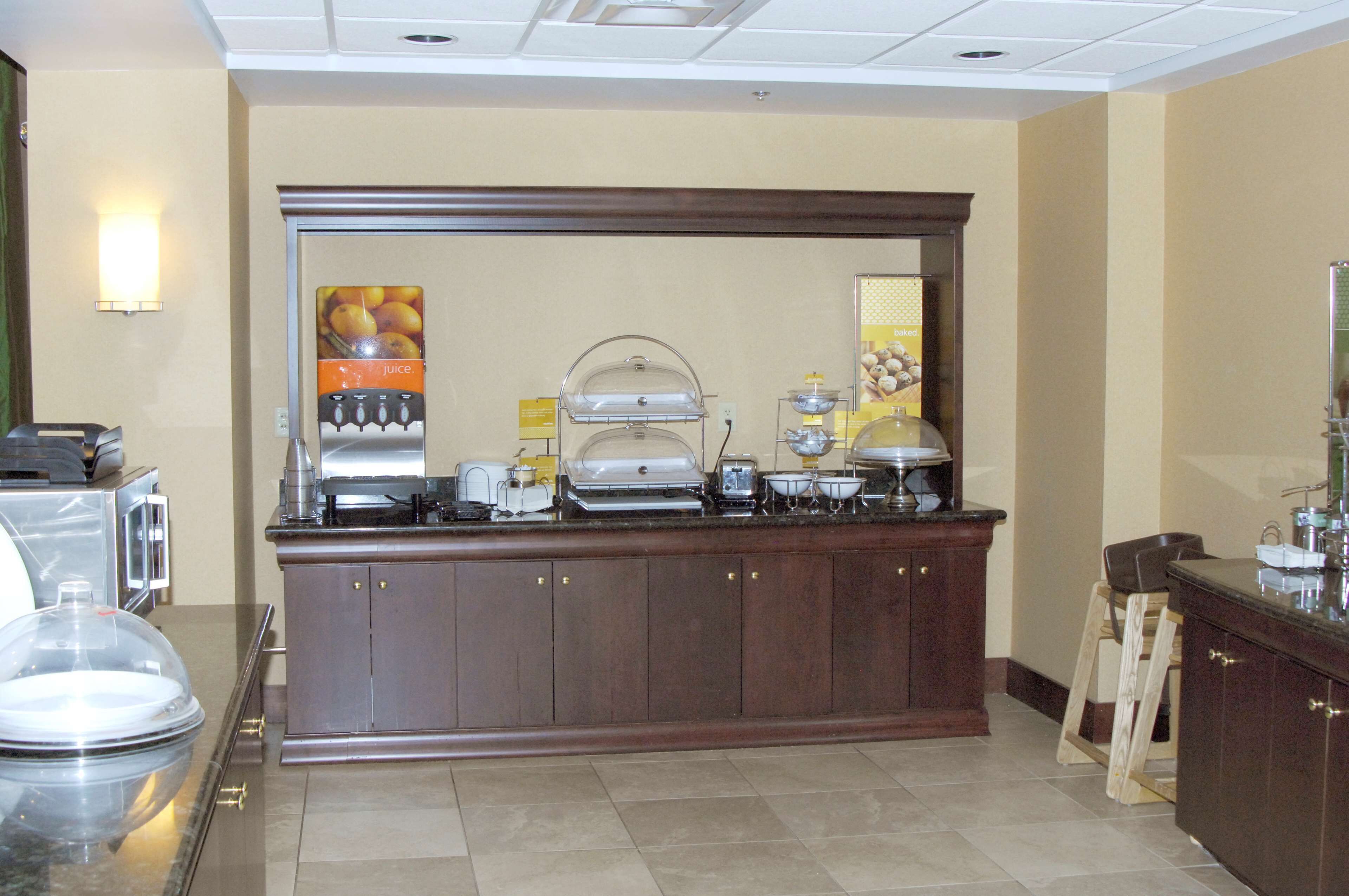 A buffet setup with various food stations, including a juice dispenser and a coffee machine.