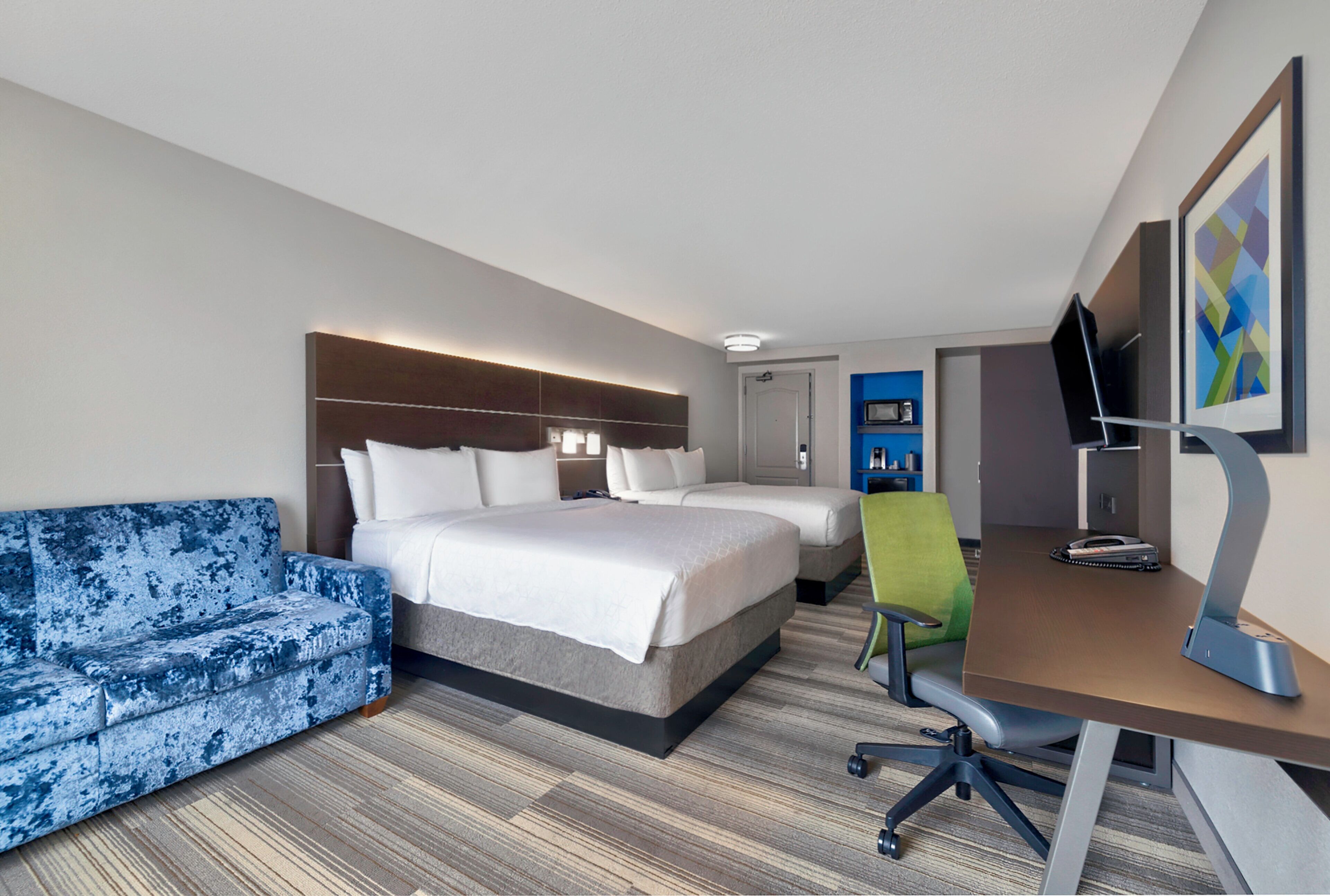 Une chambre d’hôtel équipée d’un lit, d’un canapé, d’un bureau et d’une télévision.