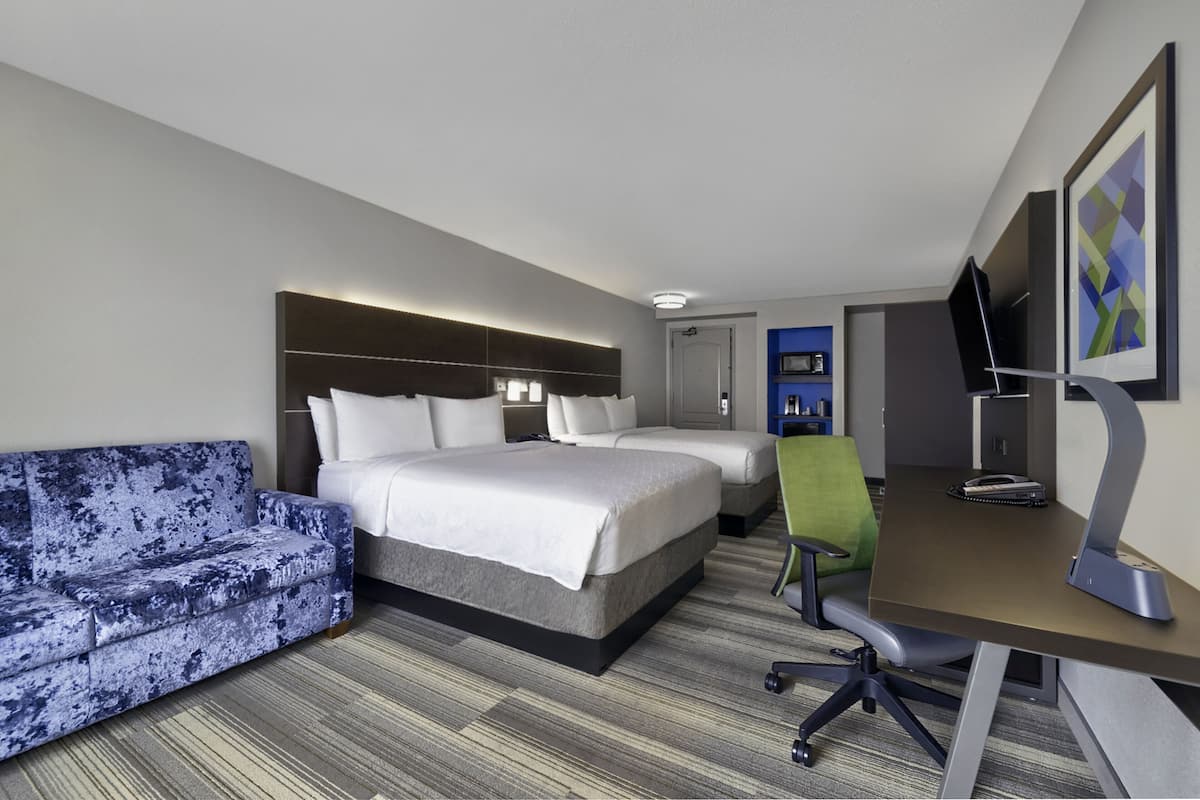 Une chambre d’hôtel équipée d’un lit, d’un canapé, d’un bureau et d’une télévision.
