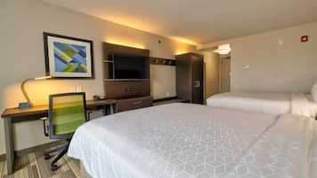 Camera d'albergo con due letti, una scrivania con sedia, TV a schermo piatto e un quadro appeso al muro.