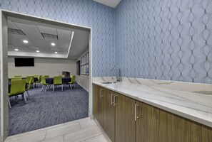 A modern hotel room with a marble countertop, wooden cabinets, and a patterned wallpaper. - Holiday Inn Express Hotel & Suites Kansas City - Grandview by IHG (Grandview)
