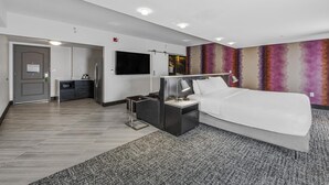 A modern hotel room with a bed, bedside table, TV, and a small desk area. - Hampton Inn & Suites Raleigh-Durham Airport-Brier Creek (Raleigh)