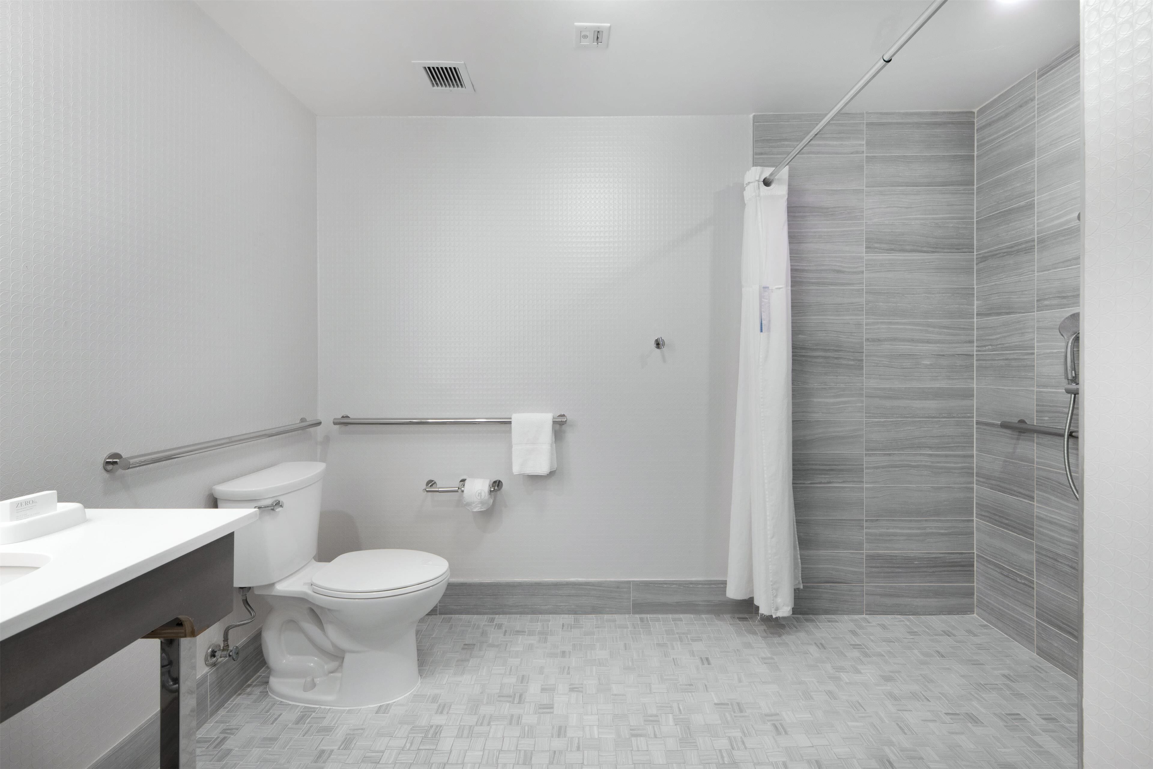 Een moderne badkamer met toilet, wastafel en douche.