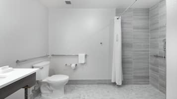 Een moderne badkamer met toilet, wastafel en douche.