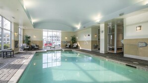 An indoor swimming pool with clear water, surrounded by lounge chairs and potted plants. - Hampton Inn & Suites Raleigh-Durham Airport-Brier Creek (Raleigh)