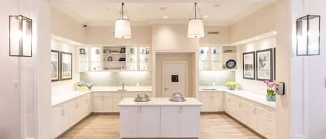 A spacious kitchen with a central island, pendant lighting, and built-in shelving.