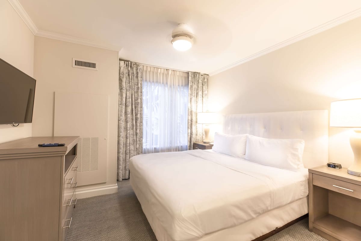 Une chambre d’hôtel avec un lit, une télévision, un bureau et une lampe.