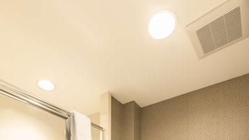 Ein Badezimmer mit Duschkabine, Toilette und Handtuchhalter mit gefalteten Handtüchern.