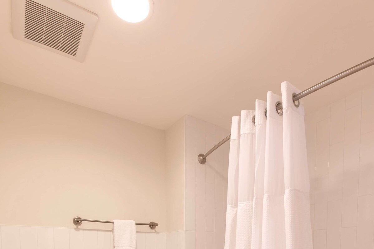 Ein Badezimmer mit Toilette, Duschvorhang und Handtuchhalter.