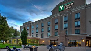 Un bâtiment de l’hôtel Holiday Inn Express doté d’une terrasse et d’une façade bien éclairée.