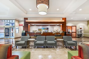 A lobby with a reception desk, seating area, and a bicycle in the background.
