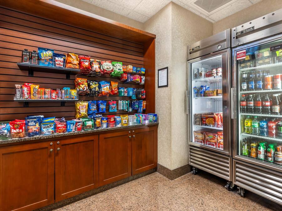Mostrador con diferentes alimentos envaselados y un expositor refrigerado para bebidas.
