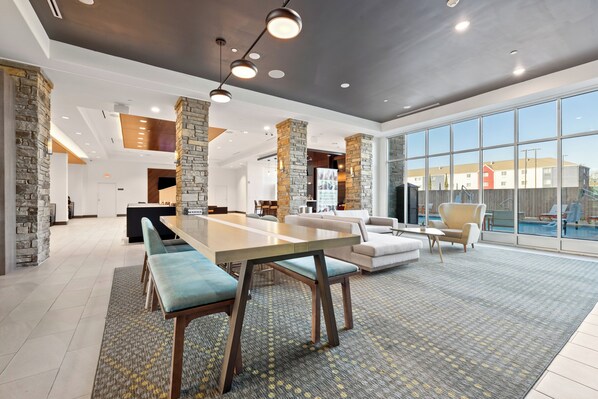 Un amplio salón con una gran mesa de comedor, asientos cómodos y vistas al exterior.